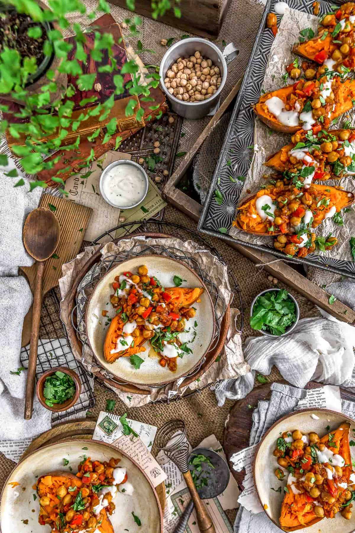 Tablescape of Moroccan Spiced Chickpeas and Garlic Sauce over sweet potatoes