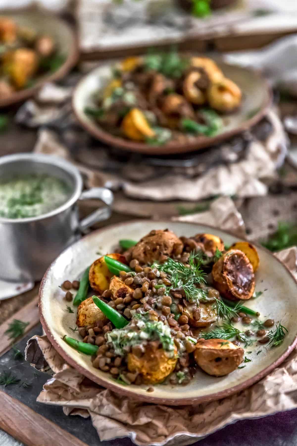 Tablescape of Roasted Potatoes with Seasoned Lentils and Dill Sauce