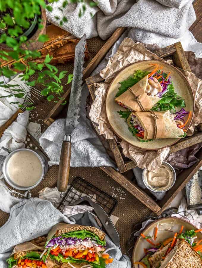 Tablescape of sandwiches and wraps with Vegan Tangy Honey Mustard Mayo