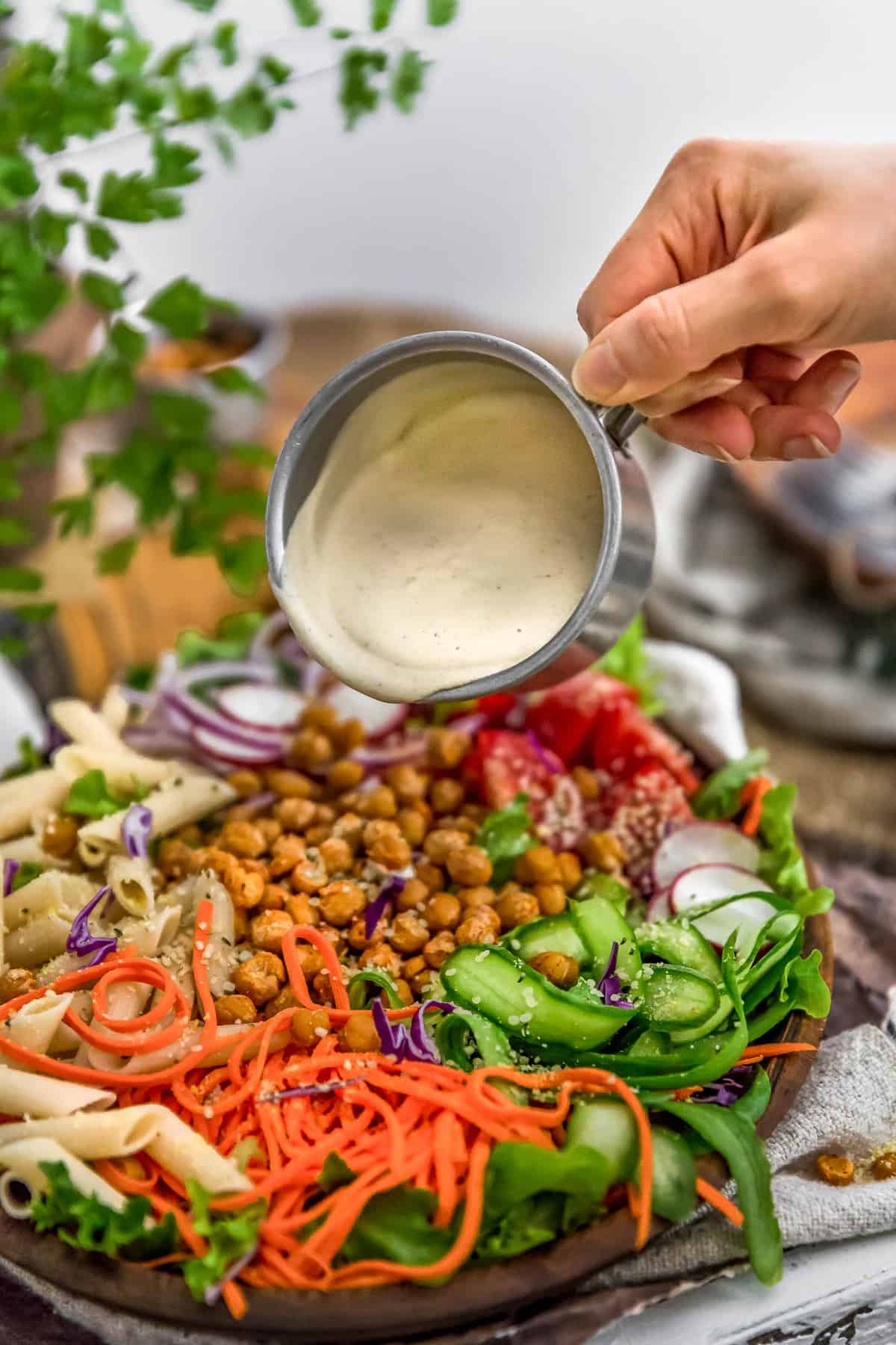 Vegan Creamy Caesar Dressing pouring over a salad