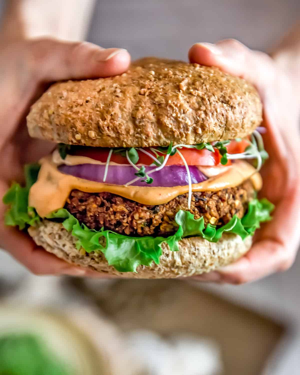 Holding the Ultimate Healthy Vegan Black Bean Burger with Special Burger Sauce