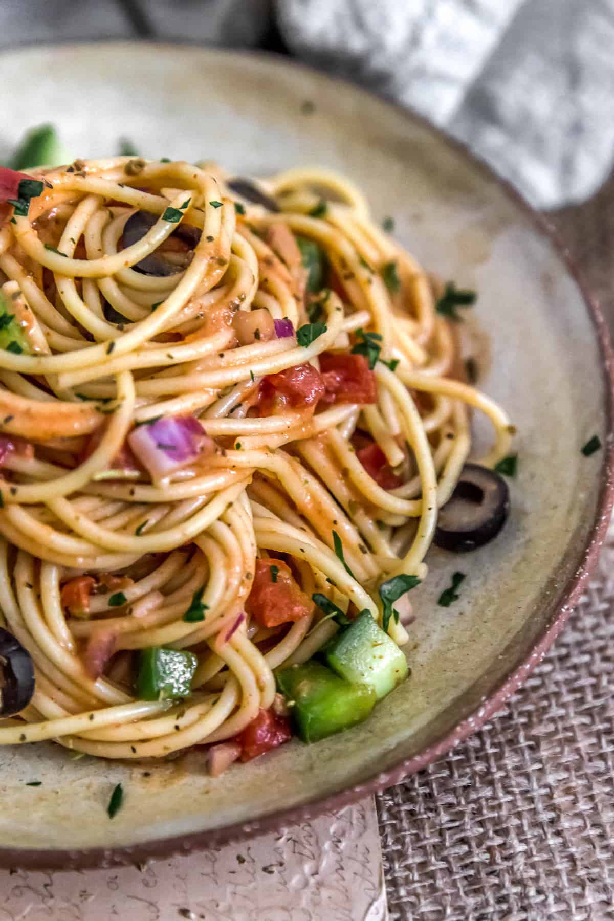 Healthy Italian Spaghetti Salad piled high on a plate