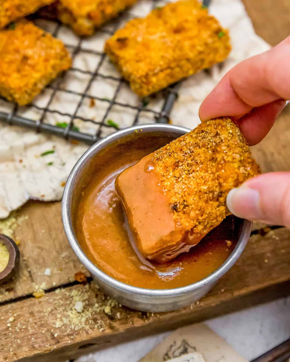 Dipping tofu nugget in Maple Mustard Dipping Sauce