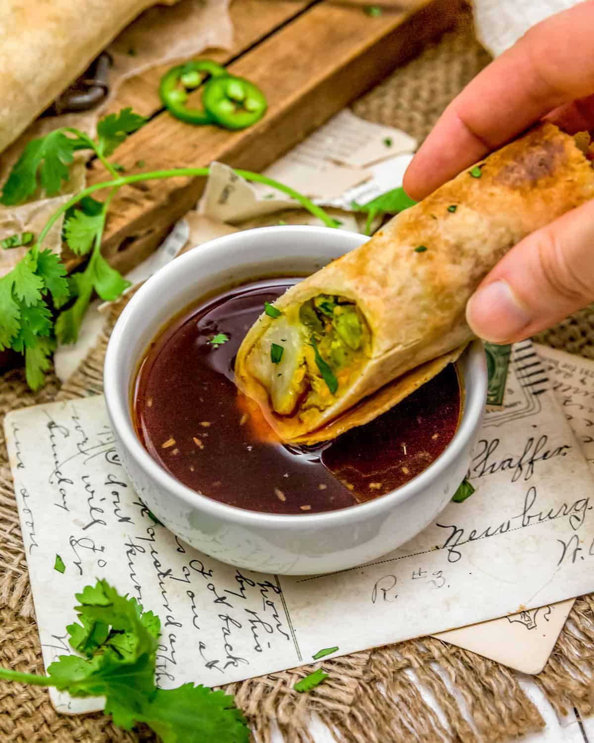 Dipping Vegan Samosa Roll in Sweet and Sour Sauce