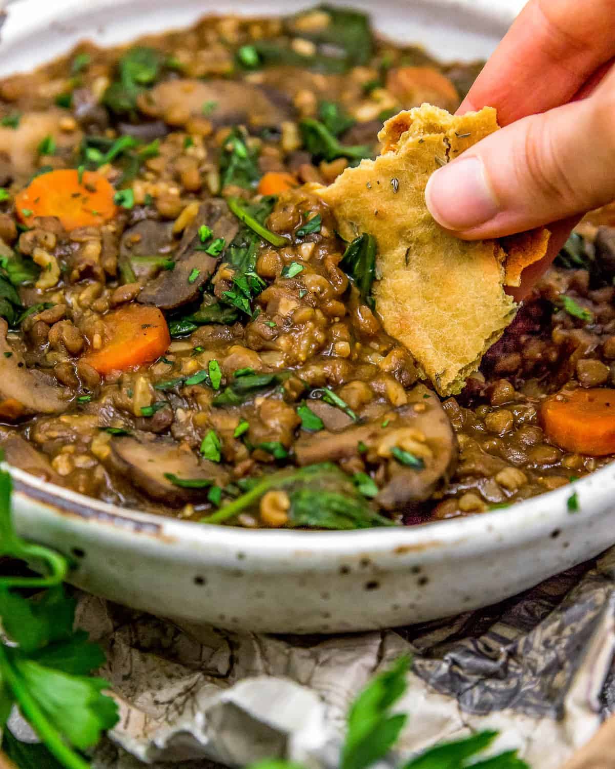 Dipping bread in French Lentil Rice Mushroom Stew