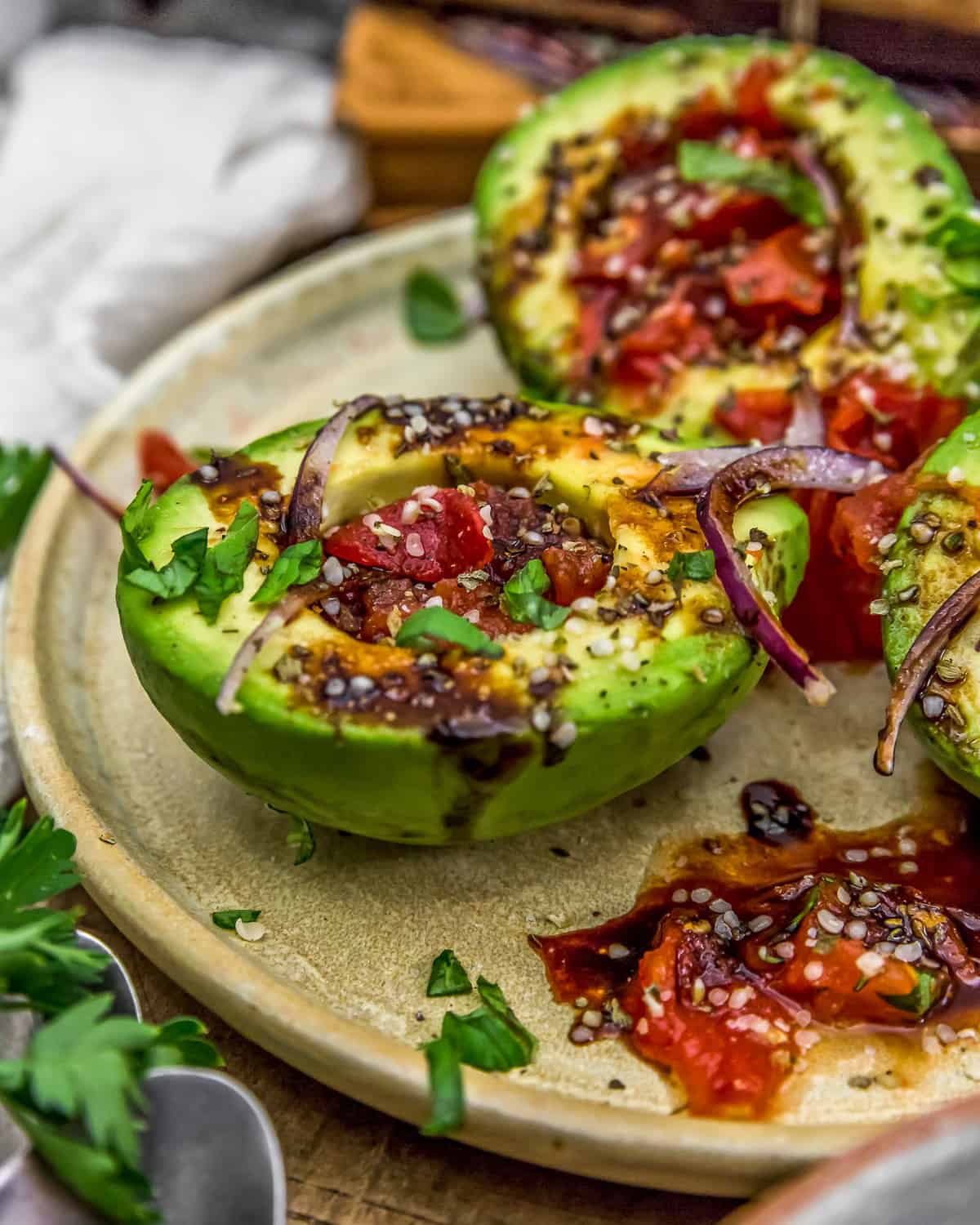 Plated Roasted Tomato Stuffed Avocados with Balsamic Reduction