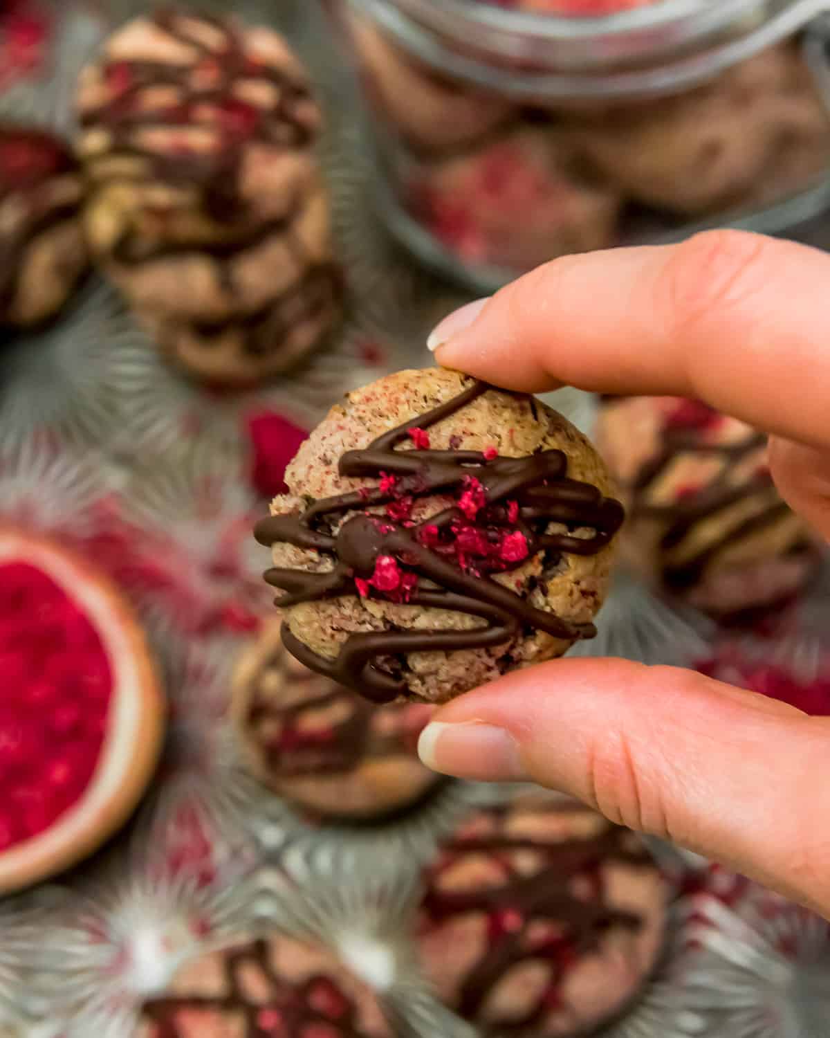 Holding a Vegan Chocolate Raspberry Cream Cookie