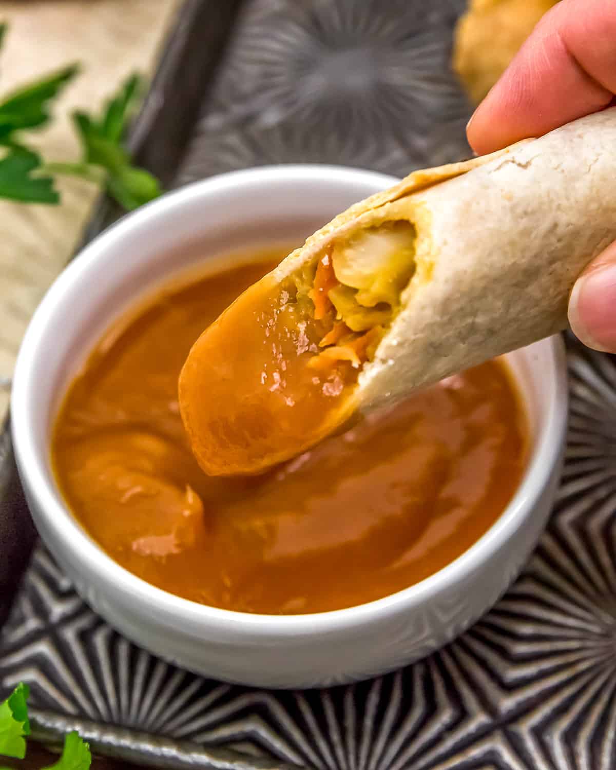 Vegan Egg Roll dipped in Sweet and Sour Sauce