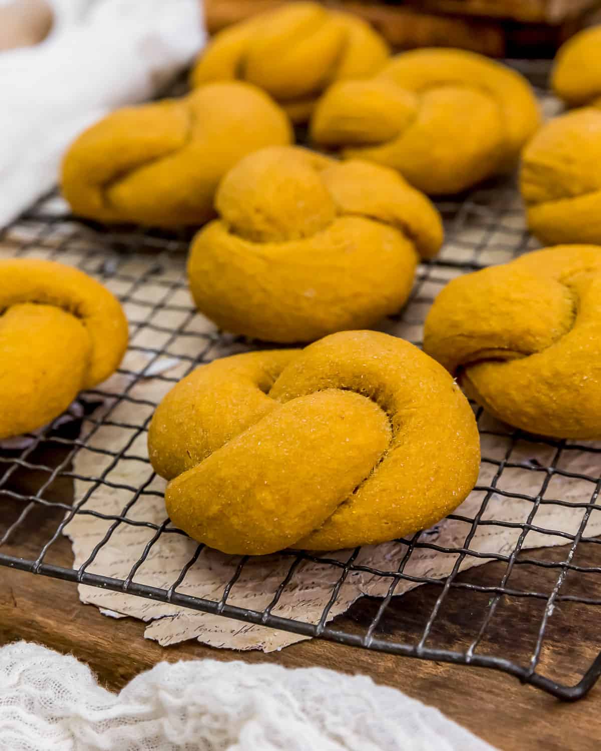 Whole Grain Pumpkin Knot Rolls on a cooling rack