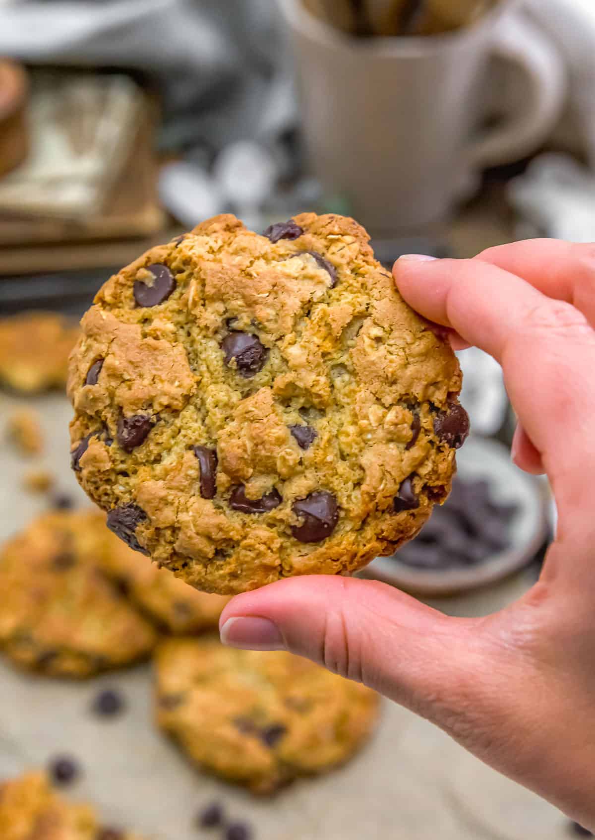 Holding a Vegan Chewy Almond Oat Chocolate Chip Cookie