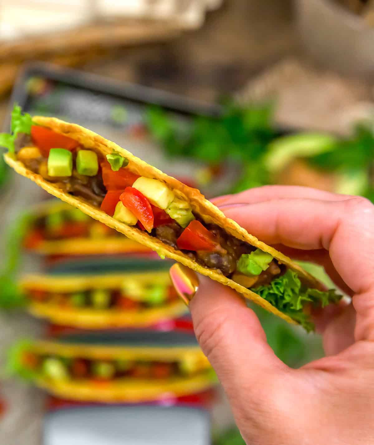 Holding a Easy Smoky Black Bean Corn Enchilada Taco